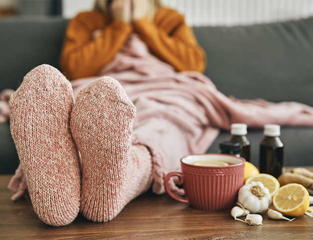 person wrapped up warm on couch due to cold